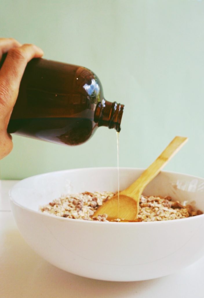 honey poured on oats and nuts mixture to make chunky granola