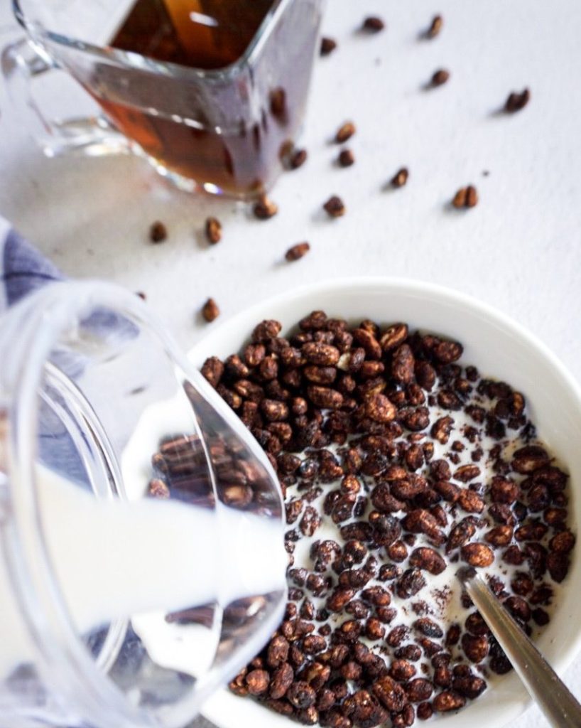 close up milk poured on cocoa puffs