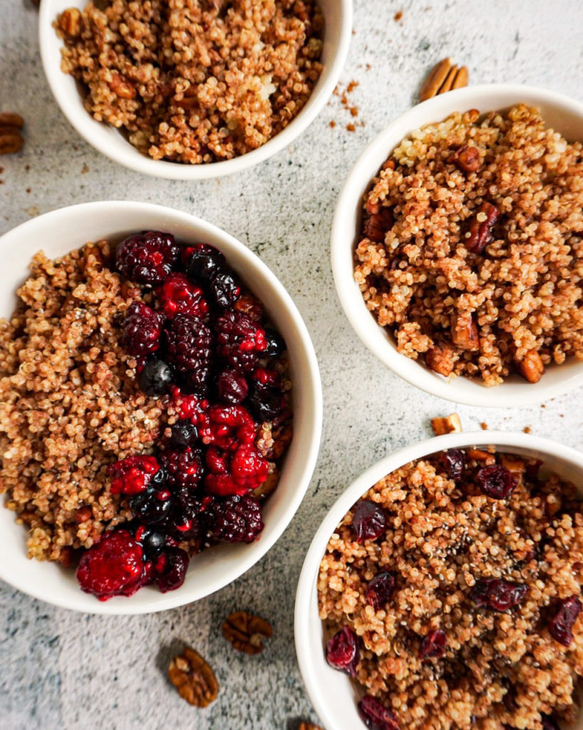 4 bowls of breakfast quinoa topped with berries