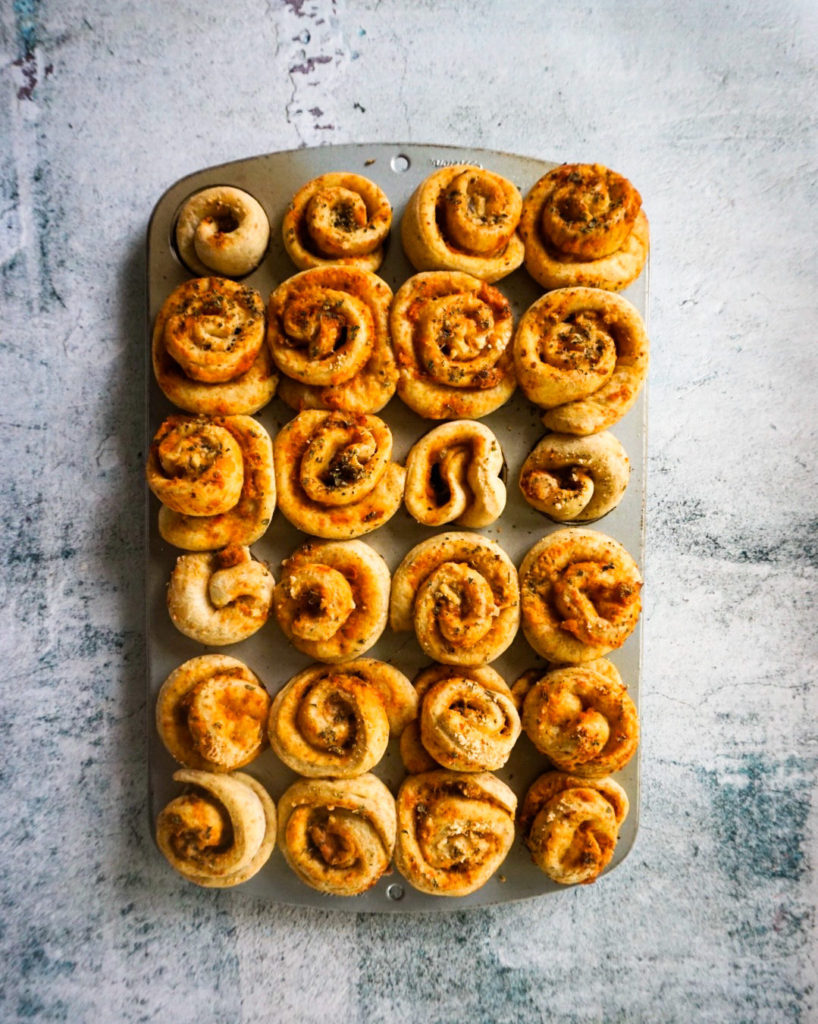 muffin tin full of baked pizza buns