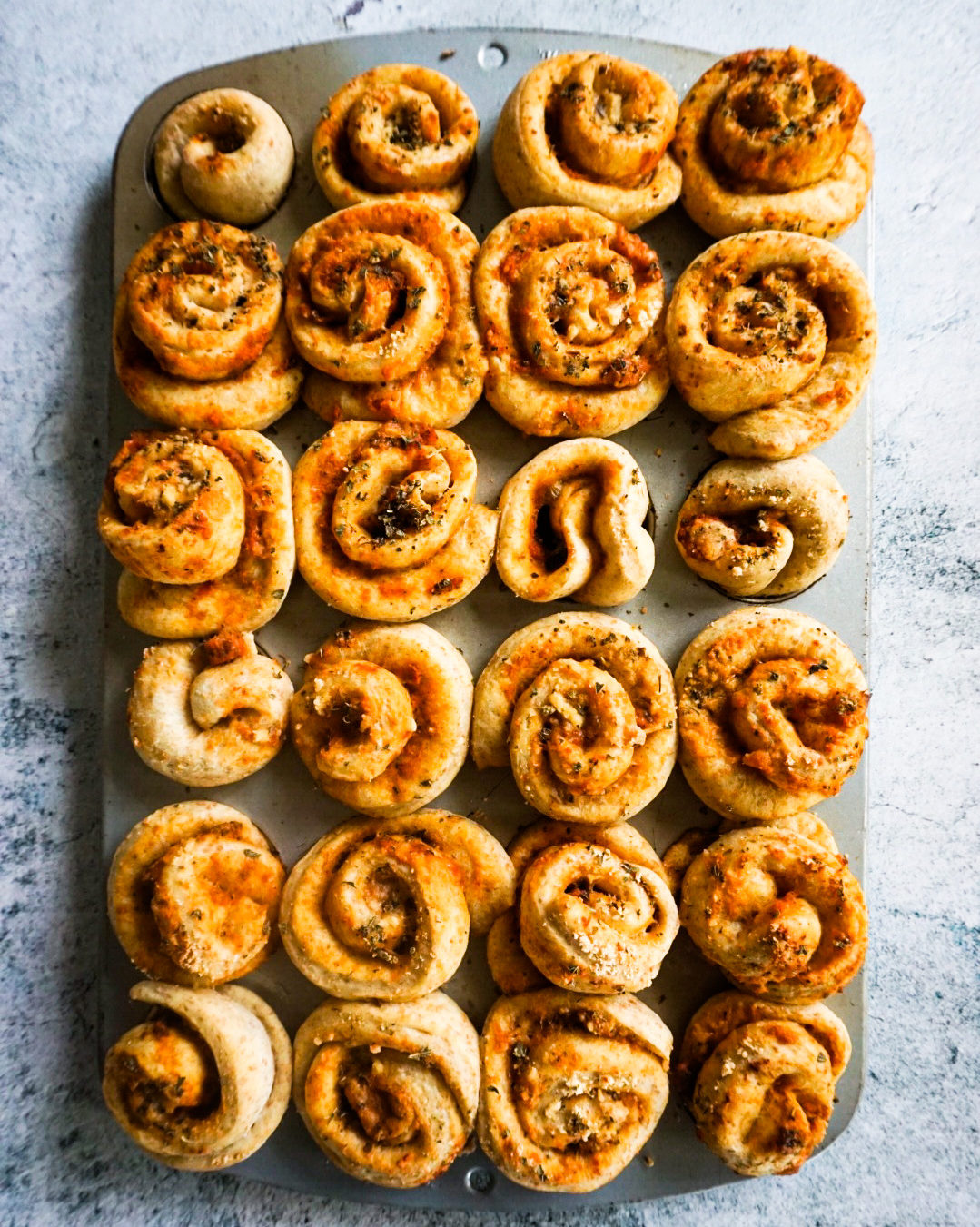 muffin tin full of pizza buns