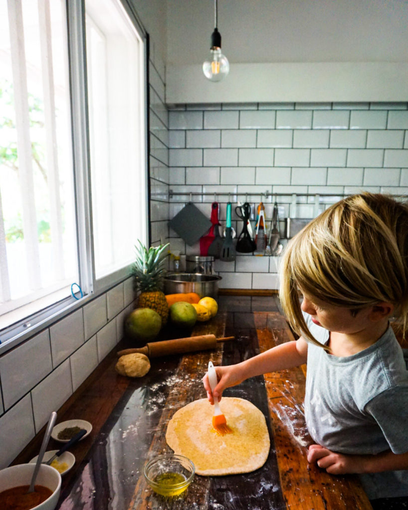 spreading olive oil on rolled out dough