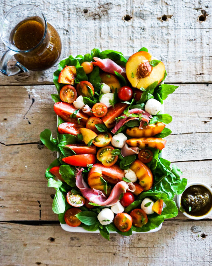 peach caprese salad with dressing and pesto