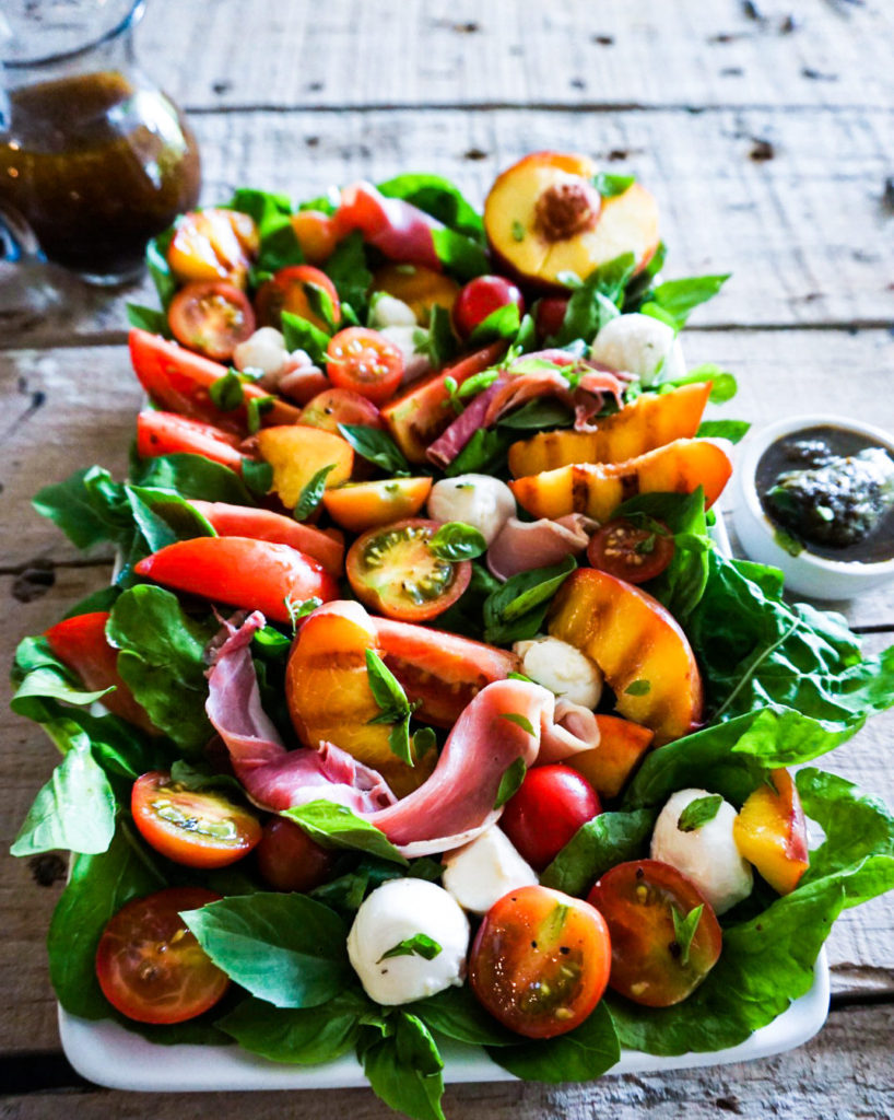 peach caprese salad with dressing and pesto