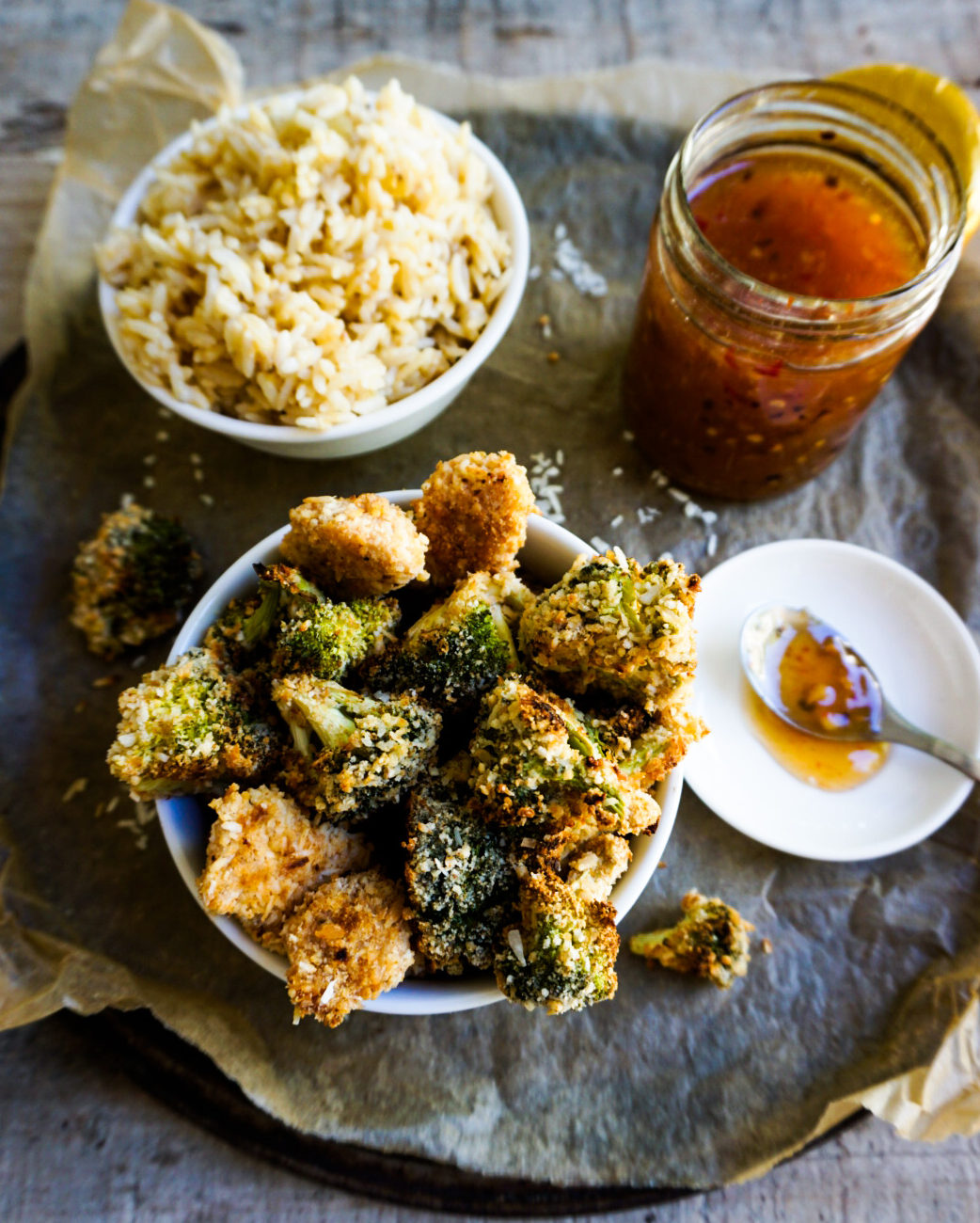 chicken, a bowl of rice and a jar of sweet chili sauce close up