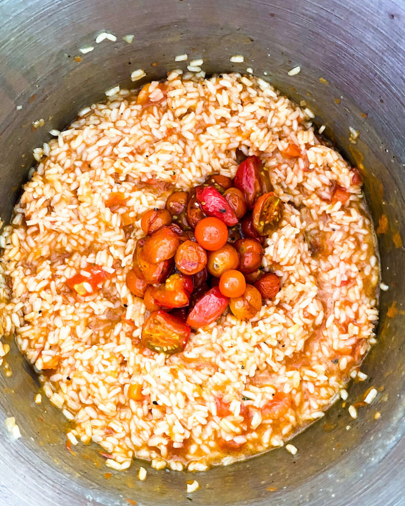 adding roasted cherry tomatoes to the risotto