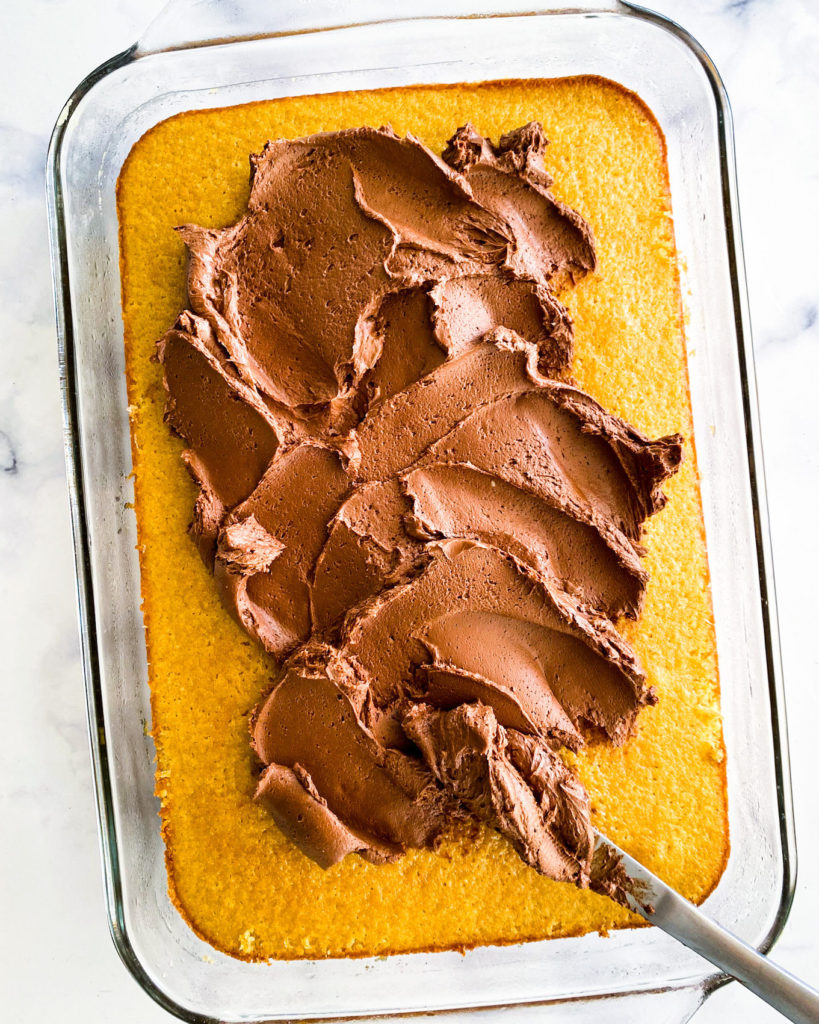 putting frosting on the sheet cake