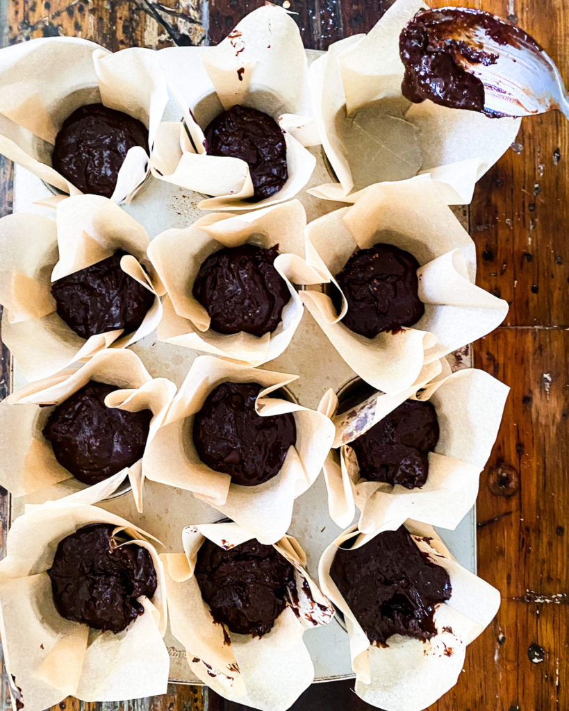 Scooping batter into a lined muffin tin