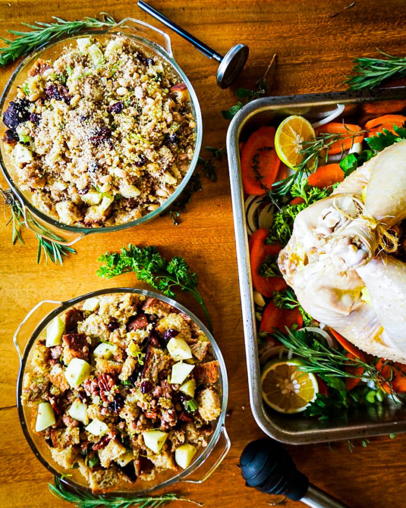 vegan and meat stuffing next to a Thanksgiving turkey that is ready to go into the oven.