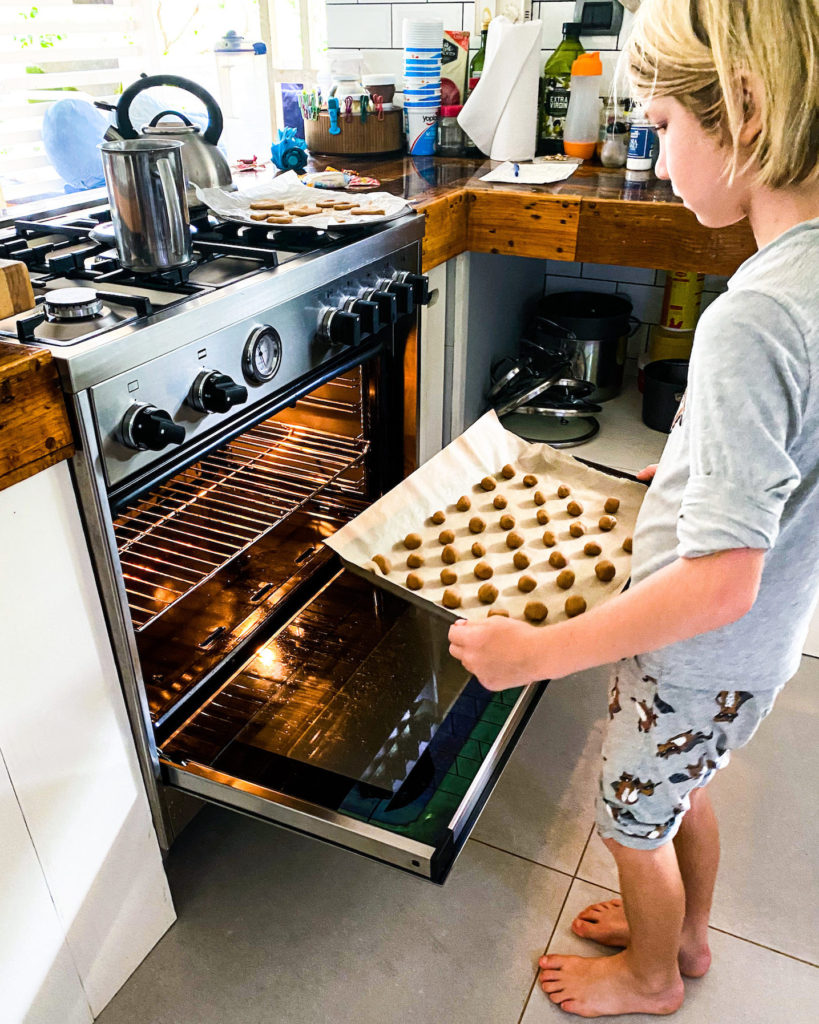 Cooper putting cookies into the oven