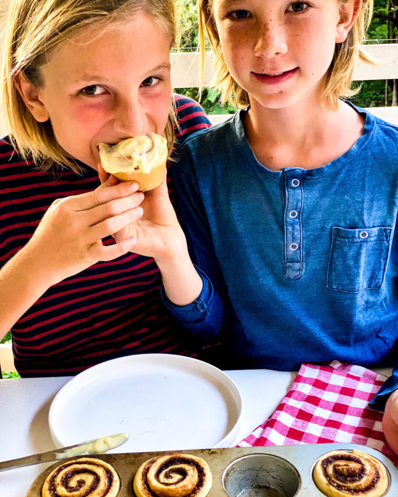 Kids taking a bite of their cinnamon roll