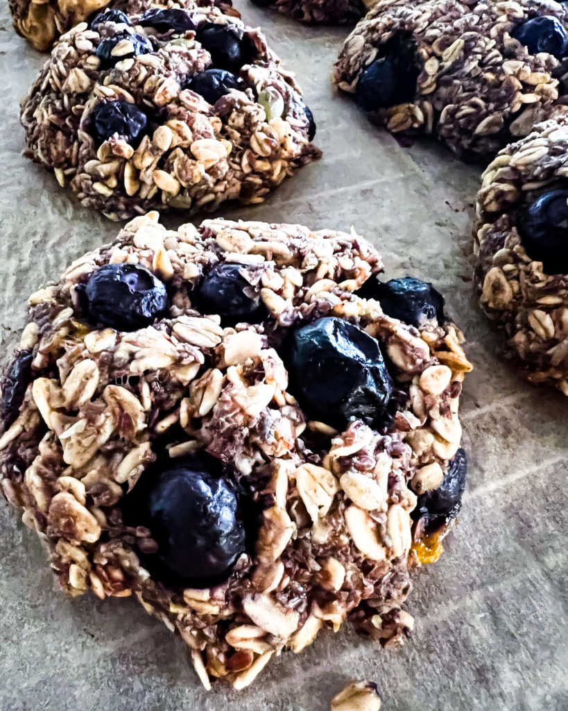 a close up of blueberry breakfast cookies cooling off on a rack