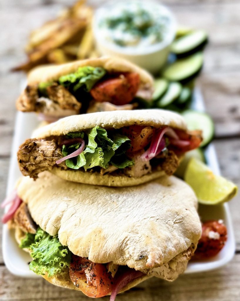 Pitas filled with lemon marinated chicken, oven baked fries, tzatziki and other toppings