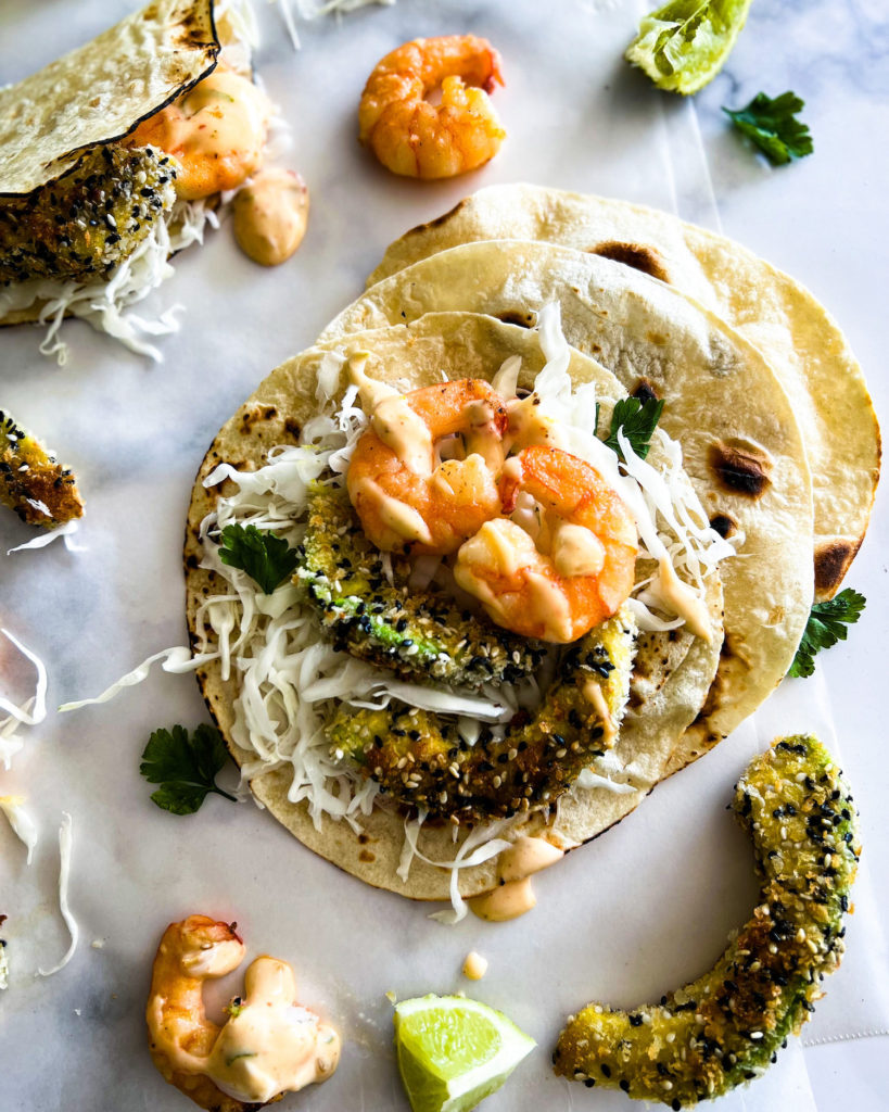 Sesame panfried avocado and shrimp tacos with sweet chili mayo close up