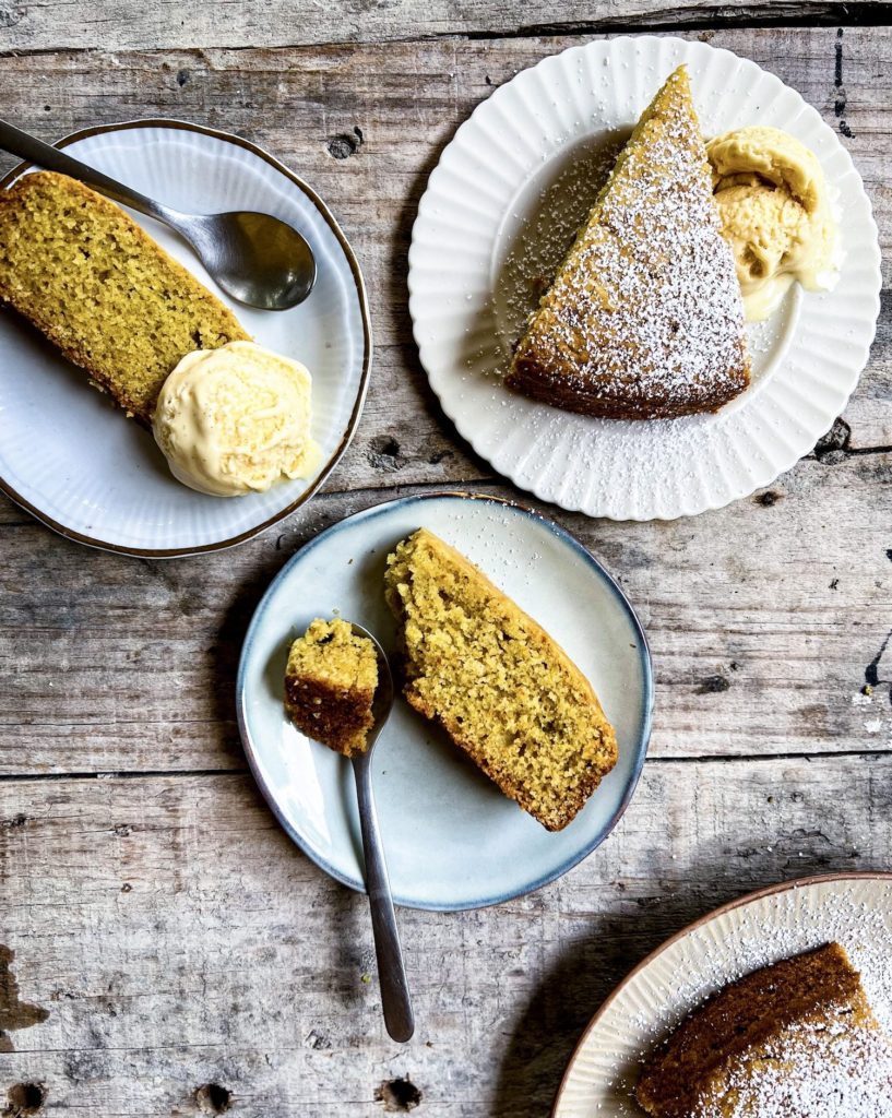 Slices of olive oil orange cake on plates with ice cream