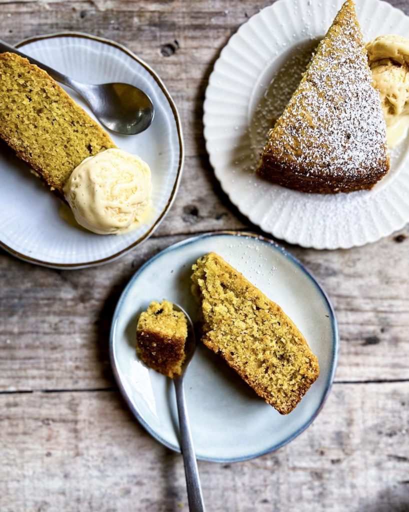 Slices of olive oil orange cake on plates with ice cream