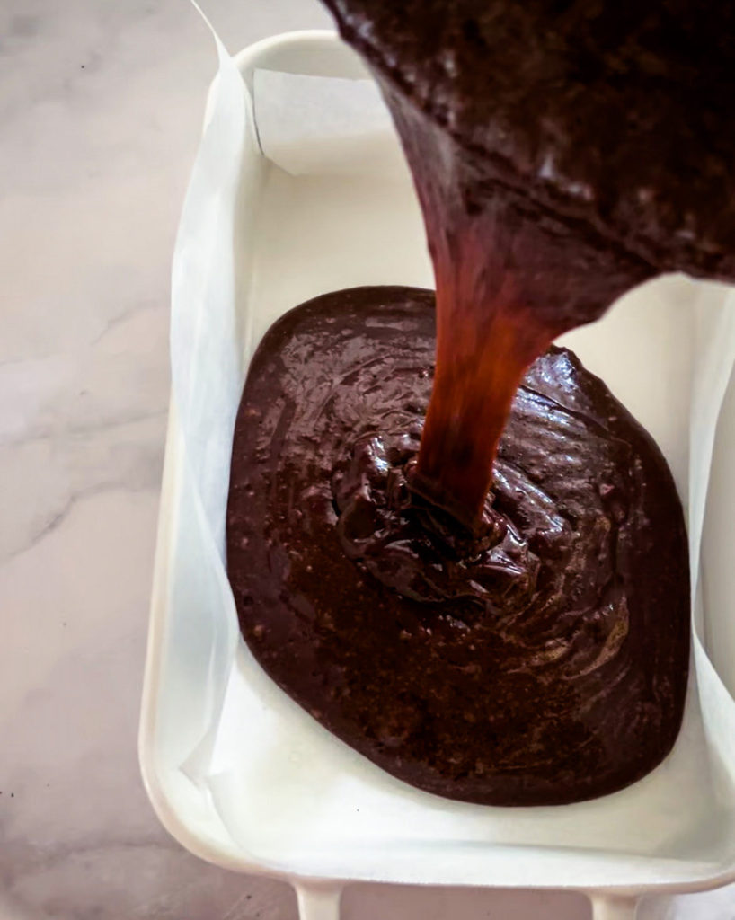 Pouring brownie batter into a baking pan