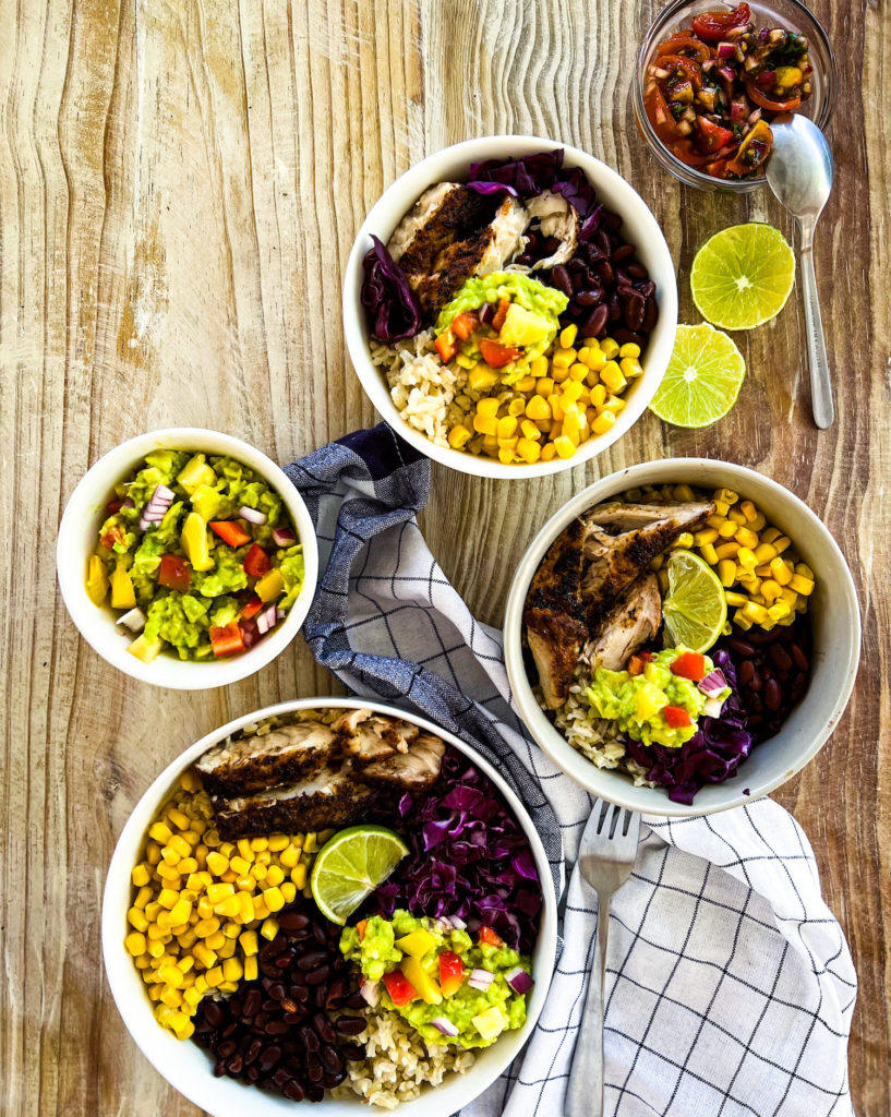 Several dishes of blackened fish taco bowl