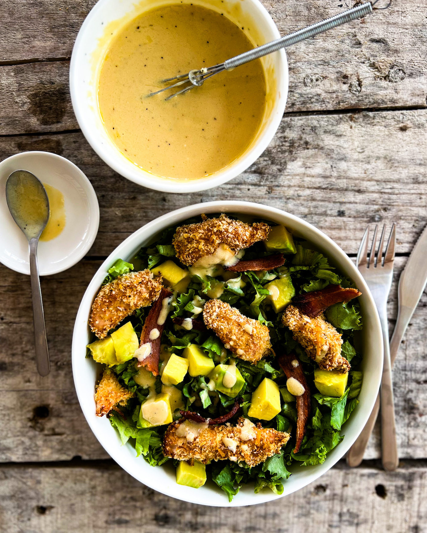 chicken finger salad in a bowl with dressing on the side